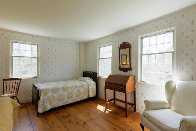 bedroom with wood-type flooring, wallpapered walls, baseboards, and ornamental molding
