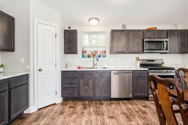 80 Dixon Rd, Lebanon, ME 04027 - kitchen with stainless steel appliances, light wood-style floors, a sink, and dark brown cabinets