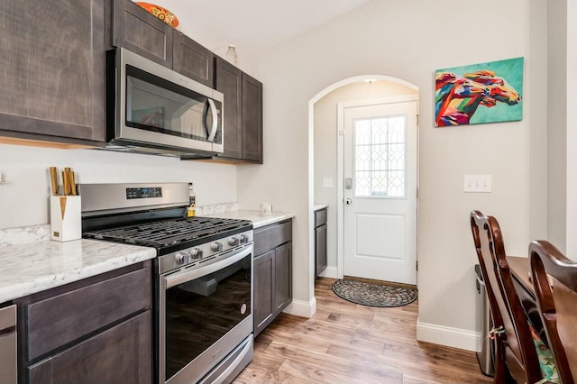 80 Dixon Rd, Lebanon, ME 04027 - kitchen with baseboards, appliances with stainless steel finishes, dark brown cabinetry, and light wood finished floors
