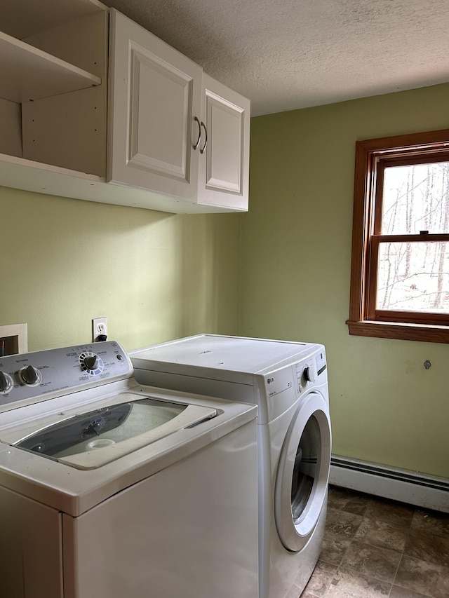 669 New Dam Rd, Waterboro, ME 04061 - clothes washing area featuring a textured ceiling, stone finish flooring, a baseboard heating unit, cabinet space, and washer and clothes dryer