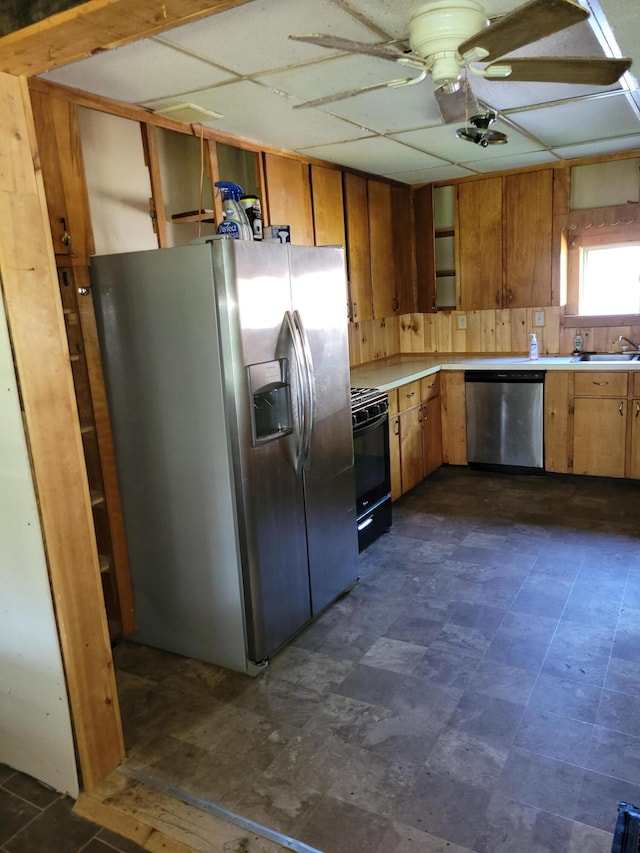 kitchen with stainless steel appliances, light countertops, brown cabinets, and ceiling fan