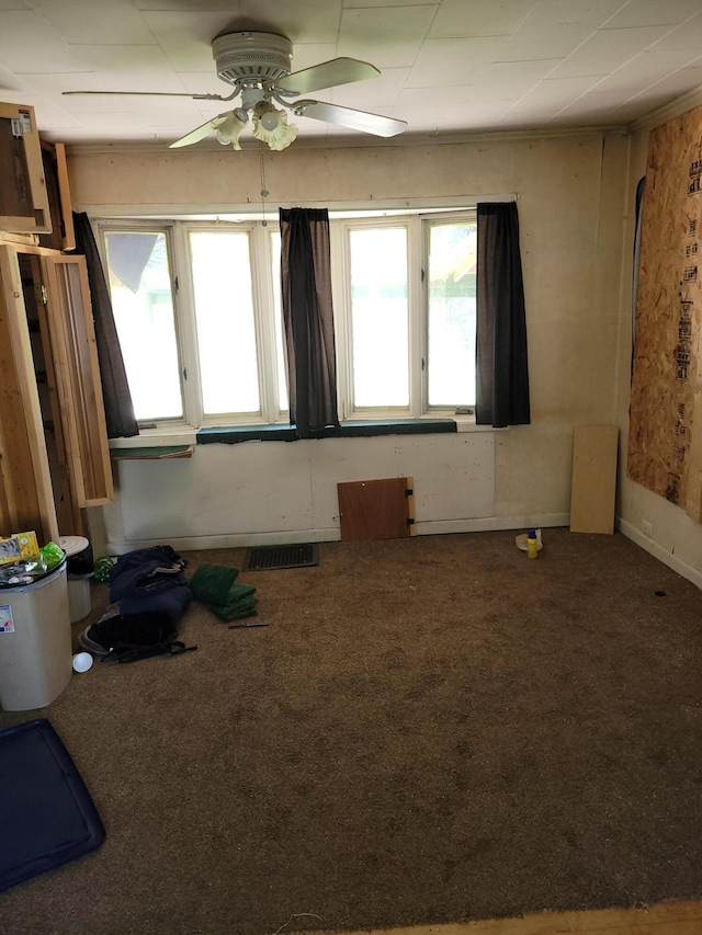 carpeted spare room with baseboards, a ceiling fan, and visible vents