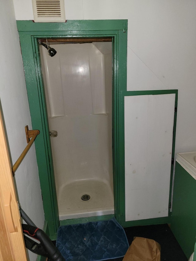 full bathroom featuring a shower stall and visible vents