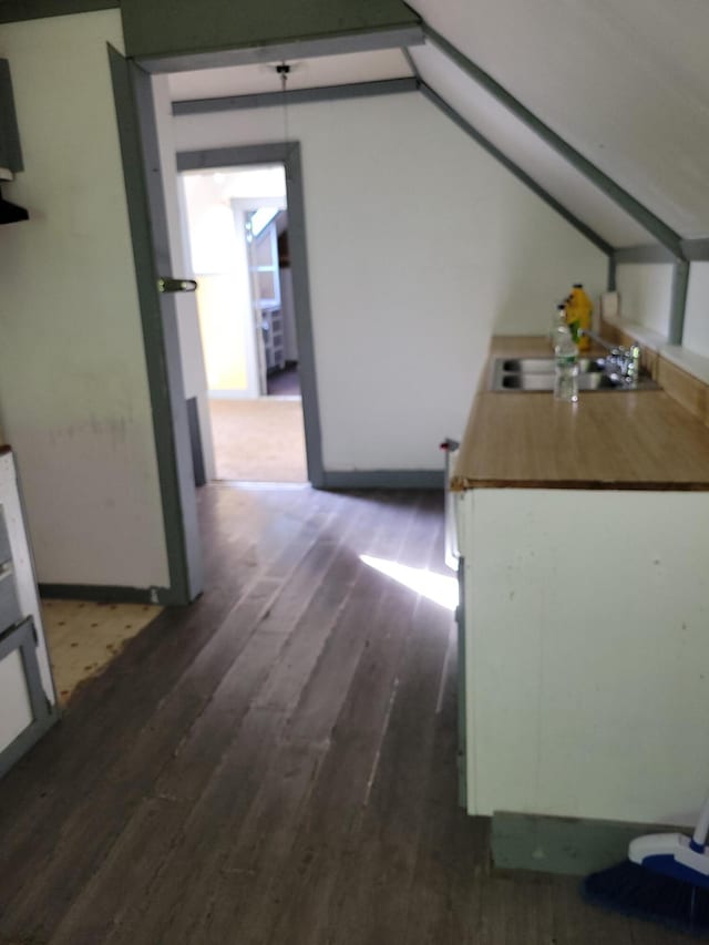 kitchen featuring dark wood-type flooring, lofted ceiling, and a sink