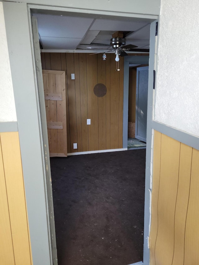 empty room featuring wooden walls and a ceiling fan