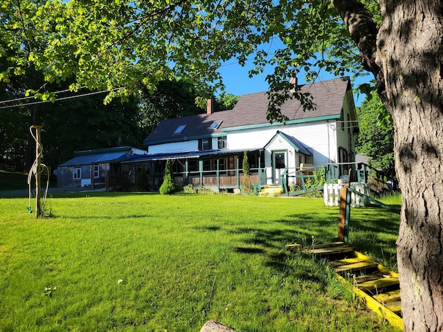 rear view of property featuring a chimney and a yard