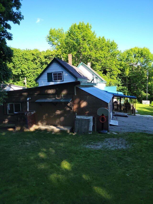 back of property with a lawn and a chimney