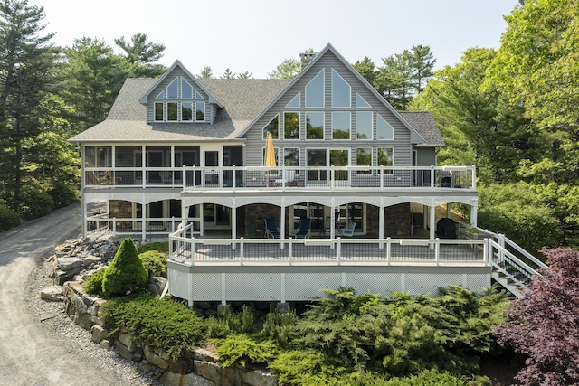 86 Firth Dr, Boothbay, ME 04537 - rear view of house with a sunroom, stone siding, a deck, and roof with shingles