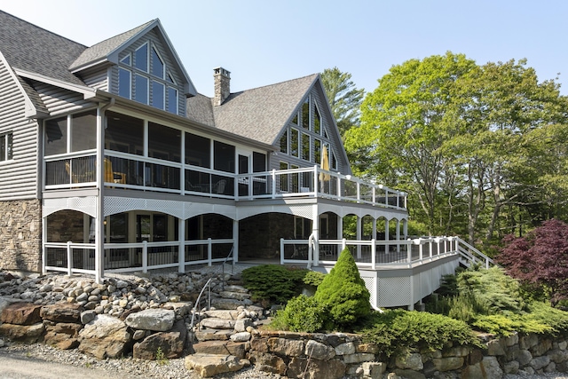 86 Firth Dr, Boothbay, ME 04537 - back of house featuring stone siding, a chimney, roof with shingles, and a sunroom