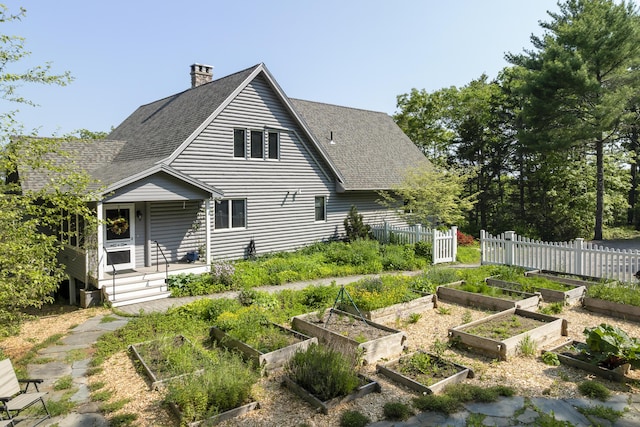 86 Firth Dr, Boothbay, ME 04537 - back of property with a vegetable garden, roof with shingles, and a chimney
