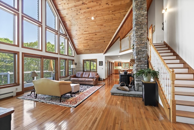 86 Firth Dr, Boothbay, ME 04537 - living area with high vaulted ceiling, ornate columns, stairs, hardwood / wood-style flooring, and a baseboard radiator