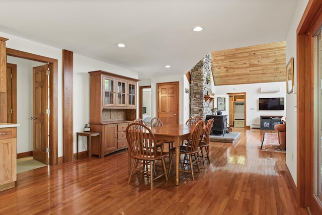 86 Firth Dr, Boothbay, ME 04537 - dining space with wood finished floors, a baseboard radiator, a wood stove, recessed lighting, and baseboards