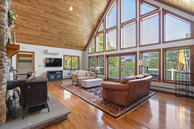 86 Firth Dr, Boothbay, ME 04537 - living area with high vaulted ceiling, wood ceiling, a baseboard radiator, wood finished floors, and a wood stove
