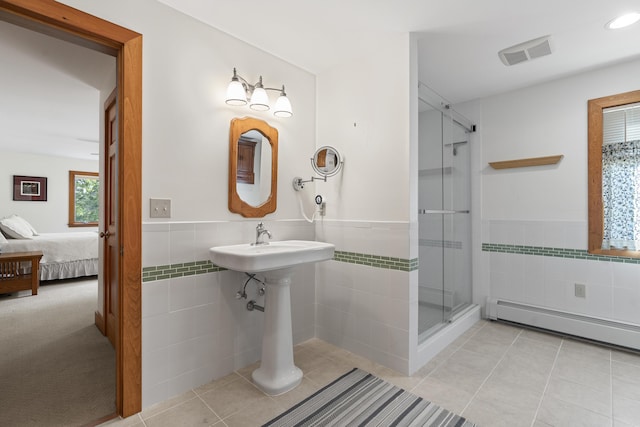 86 Firth Dr, Boothbay, ME 04537 - ensuite bathroom with tile walls, a shower stall, a wainscoted wall, tile patterned flooring, and baseboard heating