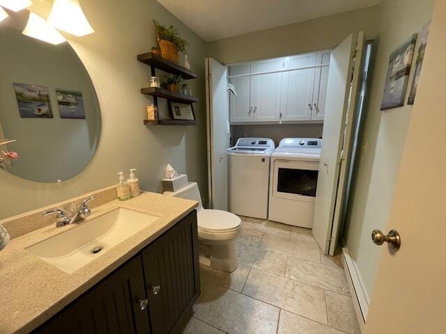 24 Clifford Rd Unit 18, Naples, ME 04055 - bathroom featuring vanity, washer and clothes dryer, baseboard heating, and toilet
