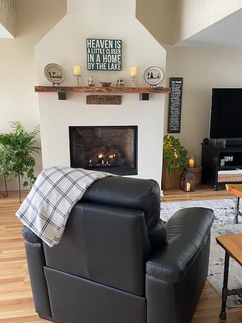 24 Clifford Rd Unit 18, Naples, ME 04055 - living area featuring light wood-style floors and a warm lit fireplace