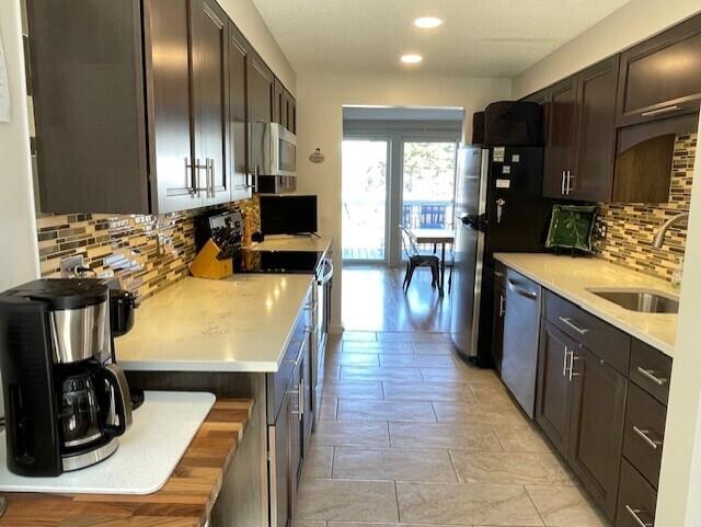 24 Clifford Rd Unit 18, Naples, ME 04055 - kitchen featuring backsplash, dark brown cabinets, light countertops, stainless steel appliances, and recessed lighting