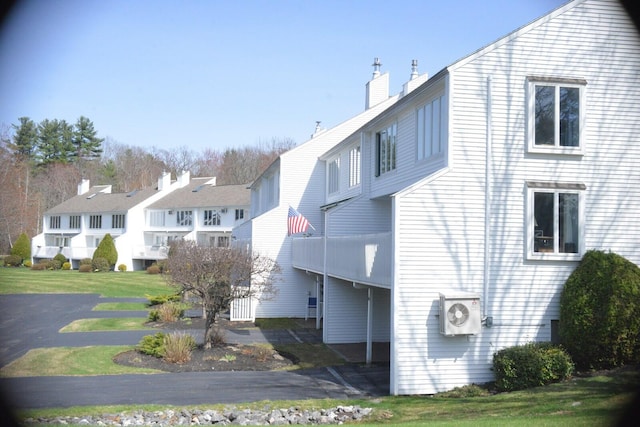 24 Clifford Rd Unit 18, Naples, ME 04055 - view of side of home with a chimney, ac unit, a lawn, and a residential view
