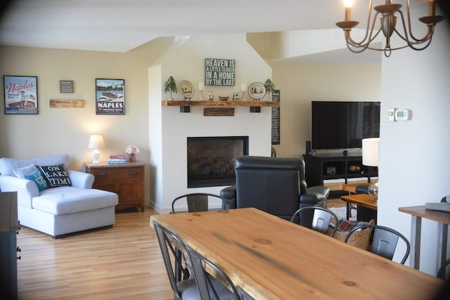 24 Clifford Rd Unit 18, Naples, ME 04055 - living area featuring baseboards, a fireplace, light wood-type flooring, and a chandelier