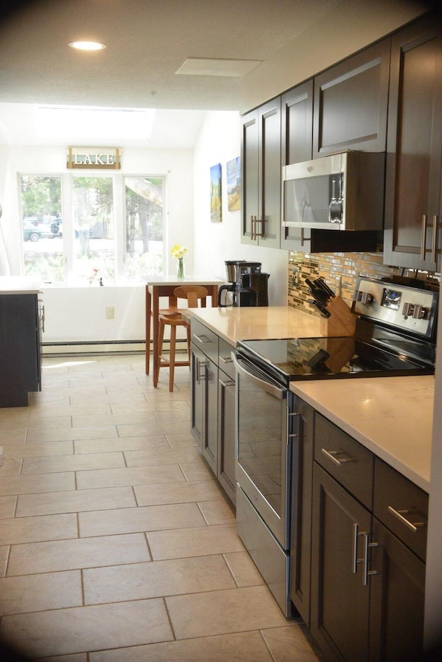 24 Clifford Rd Unit 18, Naples, ME 04055 - kitchen featuring decorative backsplash, baseboard heating, recessed lighting, light countertops, and stainless steel appliances