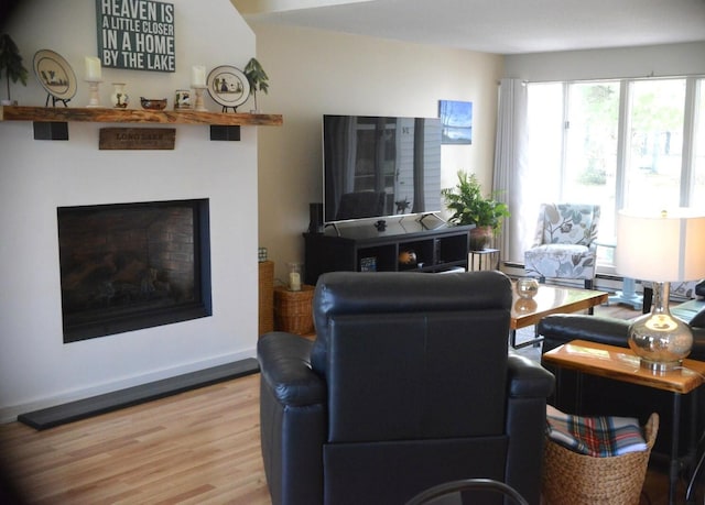 24 Clifford Rd Unit 18, Naples, ME 04055 - living area featuring a fireplace, a baseboard heating unit, and wood finished floors