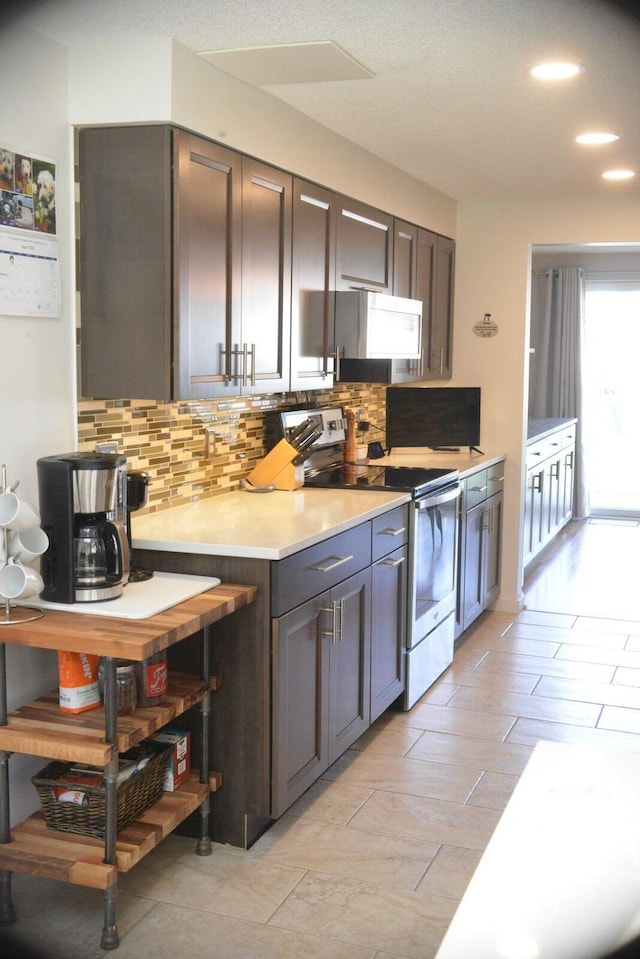 24 Clifford Rd Unit 18, Naples, ME 04055 - kitchen featuring stainless steel electric stove, light countertops, tasteful backsplash, and white microwave