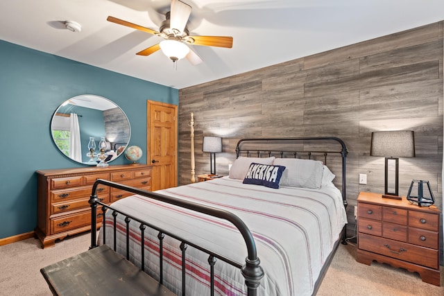 214 Gore Rd, Naples, ME 04055 - bedroom featuring light carpet, wooden walls, baseboards, a ceiling fan, and an accent wall