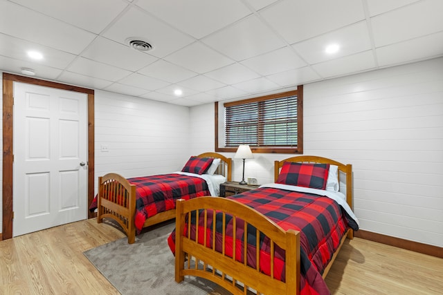 214 Gore Rd, Naples, ME 04055 - bedroom with wood finished floors, a paneled ceiling, baseboards, wood walls, and recessed lighting