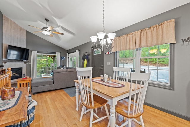 214 Gore Rd, Naples, ME 04055 - dining space featuring a chandelier, light wood finished floors, lofted ceiling, a ceiling fan, and a large fireplace