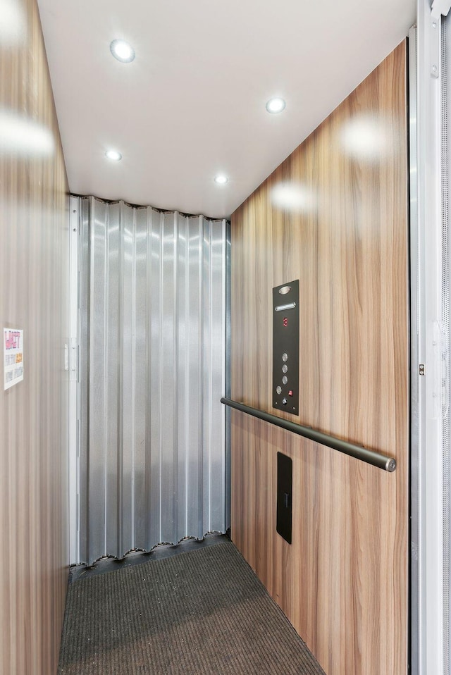 interior details featuring recessed lighting, carpet, and elevator
