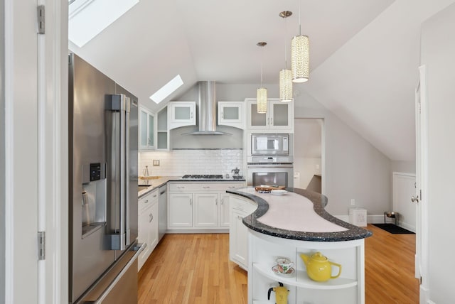kitchen featuring light wood-type flooring, appliances with stainless steel finishes, wall chimney exhaust hood, and open shelves