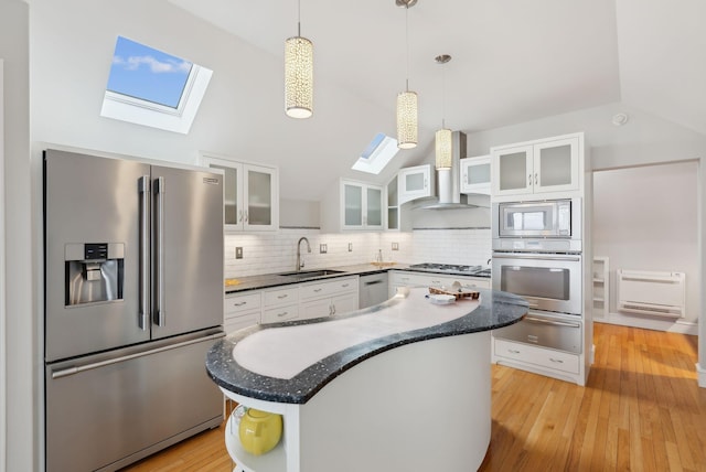 kitchen featuring a warming drawer, a skylight, a sink, and appliances with stainless steel finishes