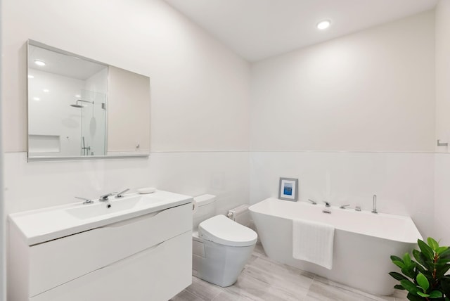 full bath with a freestanding bath, toilet, recessed lighting, vanity, and a stall shower