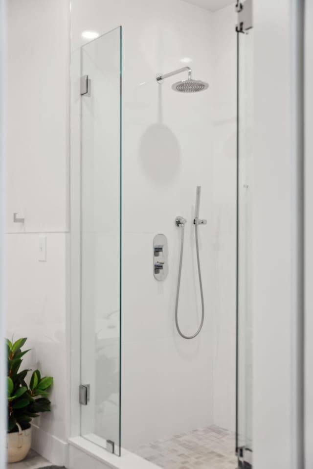 bathroom featuring a marble finish shower