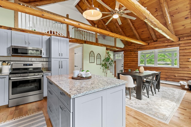 60 Line Rd, Buxton, ME 04093 - kitchen with appliances with stainless steel finishes, wood ceiling with exposed beams, rustic walls, high vaulted ceiling, and light wood finished floors