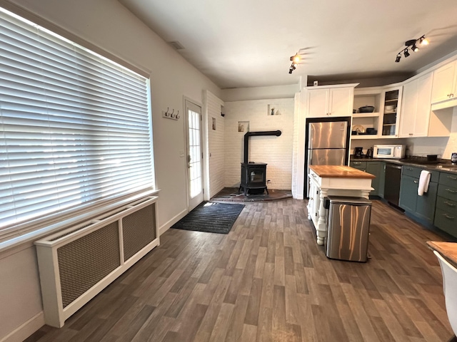 60 Elm St, Bangor, ME 04401 - kitchen featuring stainless steel appliances, a wood stove, white cabinets, open shelves, and wooden counters