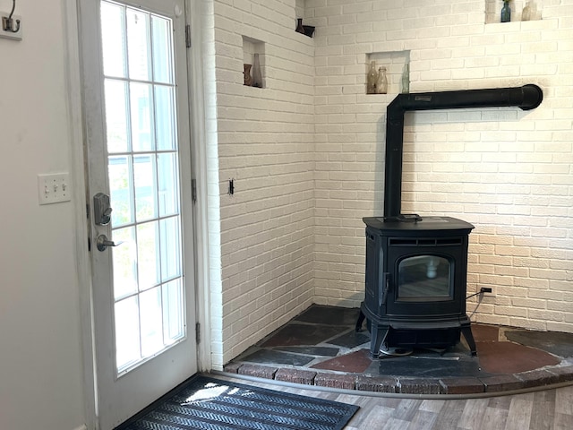 60 Elm St, Bangor, ME 04401 - detailed view of a wood stove, wood finished floors, and brick wall