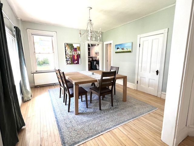 60 Elm St, Bangor, ME 04401 - dining area with radiator heating unit, a chandelier, wood-type flooring, ornamental molding, and baseboards
