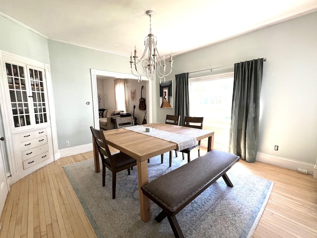 60 Elm St, Bangor, ME 04401 - dining room with a chandelier, light wood-style flooring, baseboards, and ornamental molding