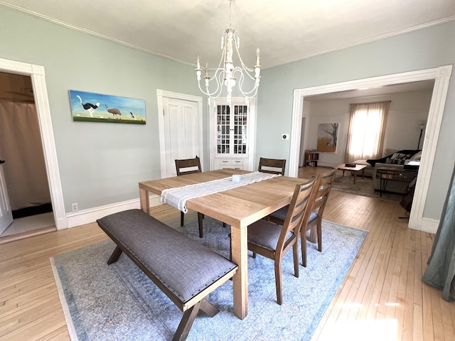 60 Elm St, Bangor, ME 04401 - dining space featuring a chandelier, light wood-type flooring, ornamental molding, and baseboards