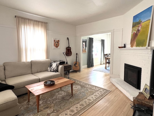 60 Elm St, Bangor, ME 04401 - living room featuring plenty of natural light, light wood-style flooring, and a brick fireplace