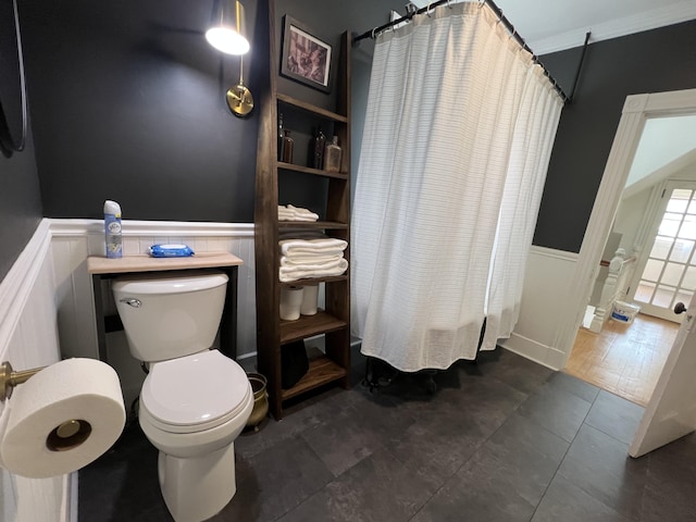 60 Elm St, Bangor, ME 04401 - bathroom featuring toilet, wainscoting, tile patterned floors, and a decorative wall