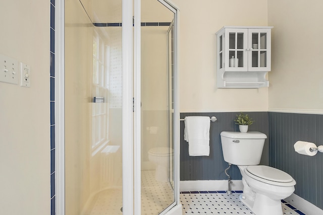 15 Obrion St Unit A, Portland, ME 04101 - bathroom with toilet, a stall shower, a wainscoted wall, and baseboards