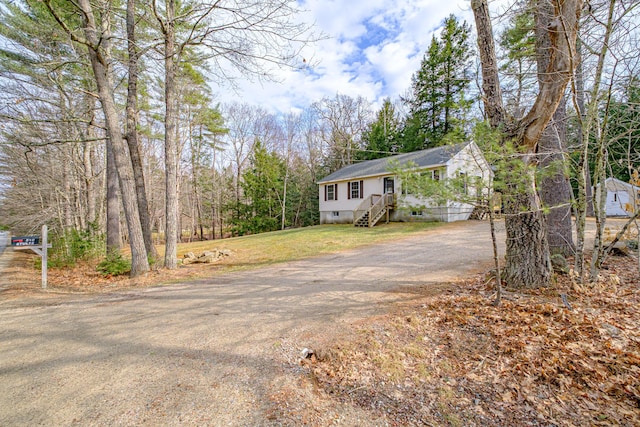 view of front of home featuring crawl space, driveway, and a shingled roof