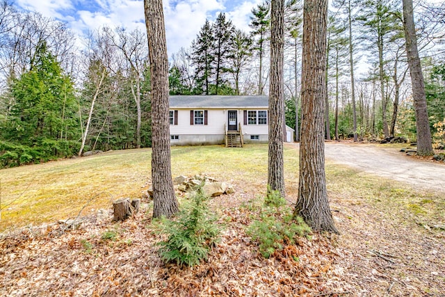 view of front of property with a front lawn, aphalt driveway, and roof with shingles