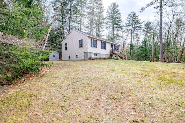 view of property exterior featuring a storage unit, a yard, and an outbuilding