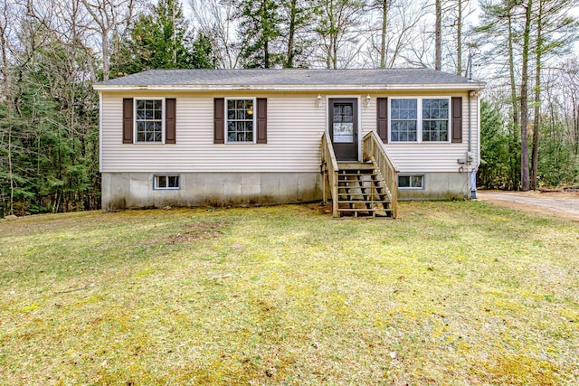 manufactured / mobile home with a shingled roof and a front yard