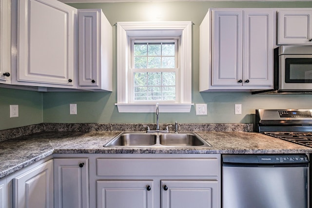 kitchen with white cabinetry, stainless steel appliances, and a sink