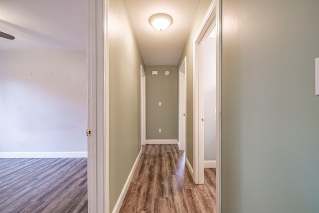 hall featuring baseboards and wood finished floors