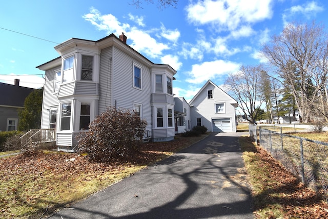 131 George St, Pittsfield, ME 04967 - view of side of home with fence, a chimney, and aphalt driveway
